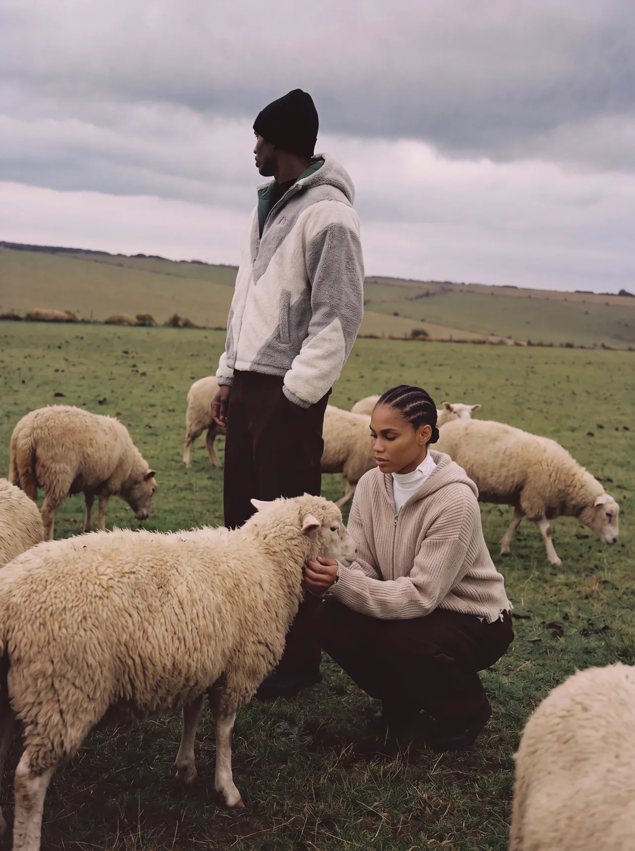 Two OCTAVE Theory models wearing the new fleece jacket and zip hoodie in a field with sheep